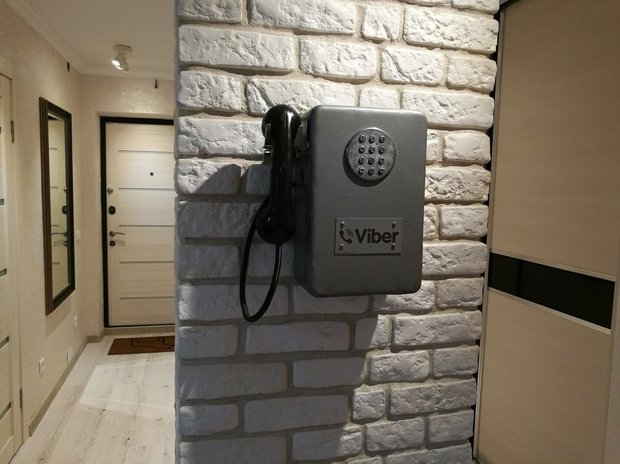 Кирпич, черный потолок и телефон-автомат в двухкомнатной квартире